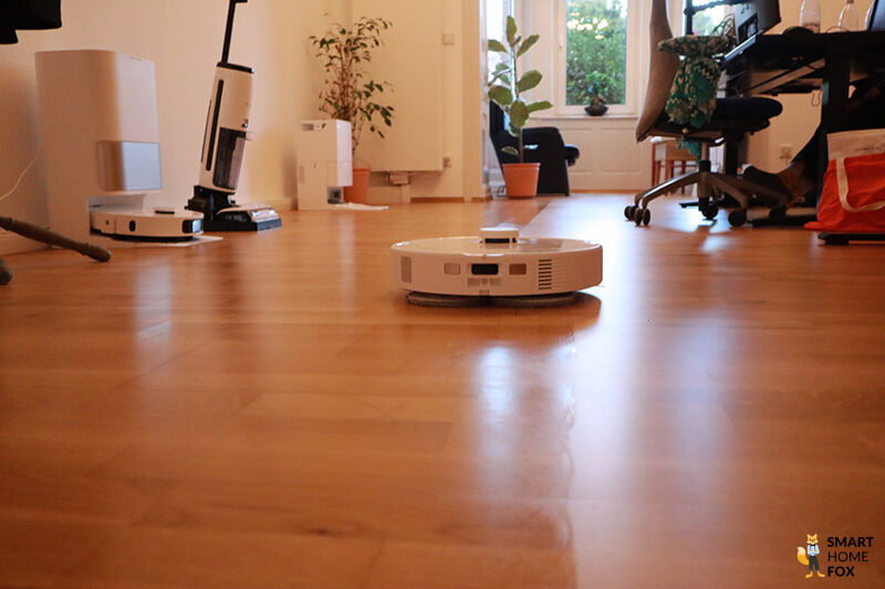 Roborock Q Revo MaxV моет пол в гостиной.